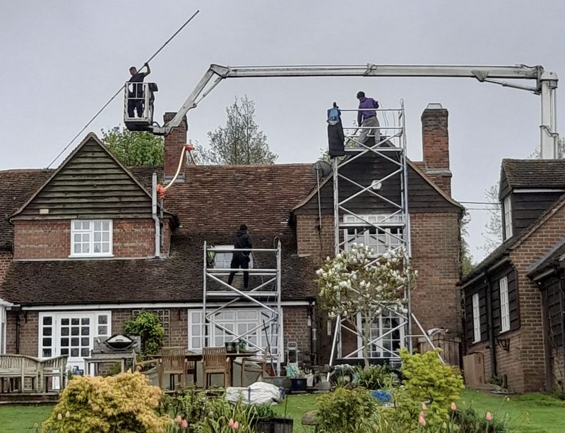The Roof Moss Cleaners using cherry picker and scaffolding to clean roof safely and professionally in Bordon, Hampshire